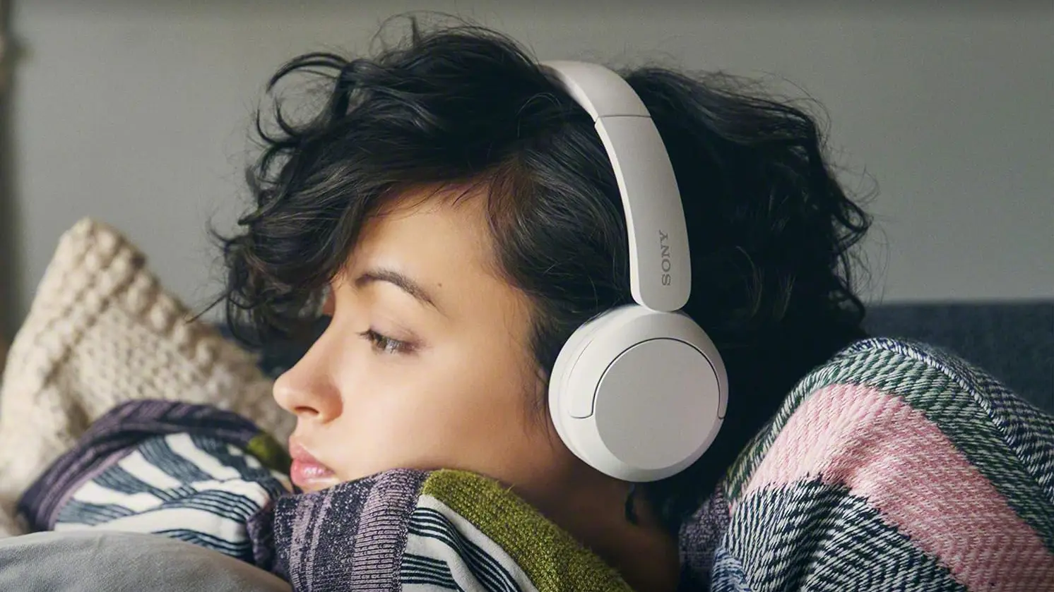 Young woman enjoying the Sony WH CH520 Bluetooth Wireless Headset as part of QTOOTH's review