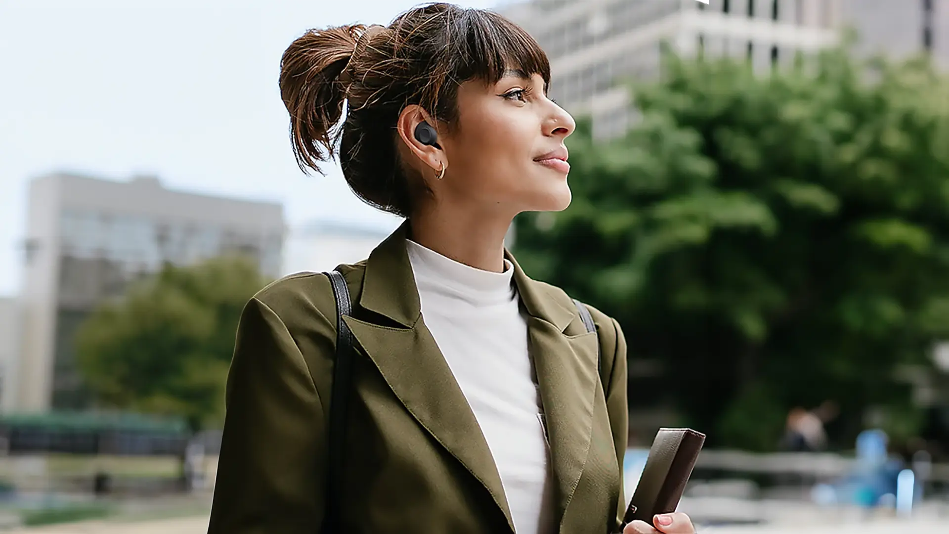 woman pictured enjoying samsung galaxy buds fe bluetooth headphones as part of a product review